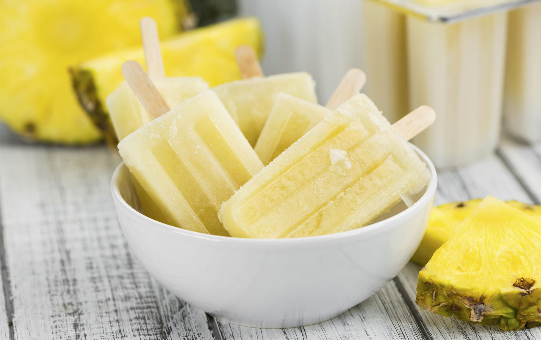 Fresh made Popsicles (Pineapple flavoured, selective focus) on a rustic background