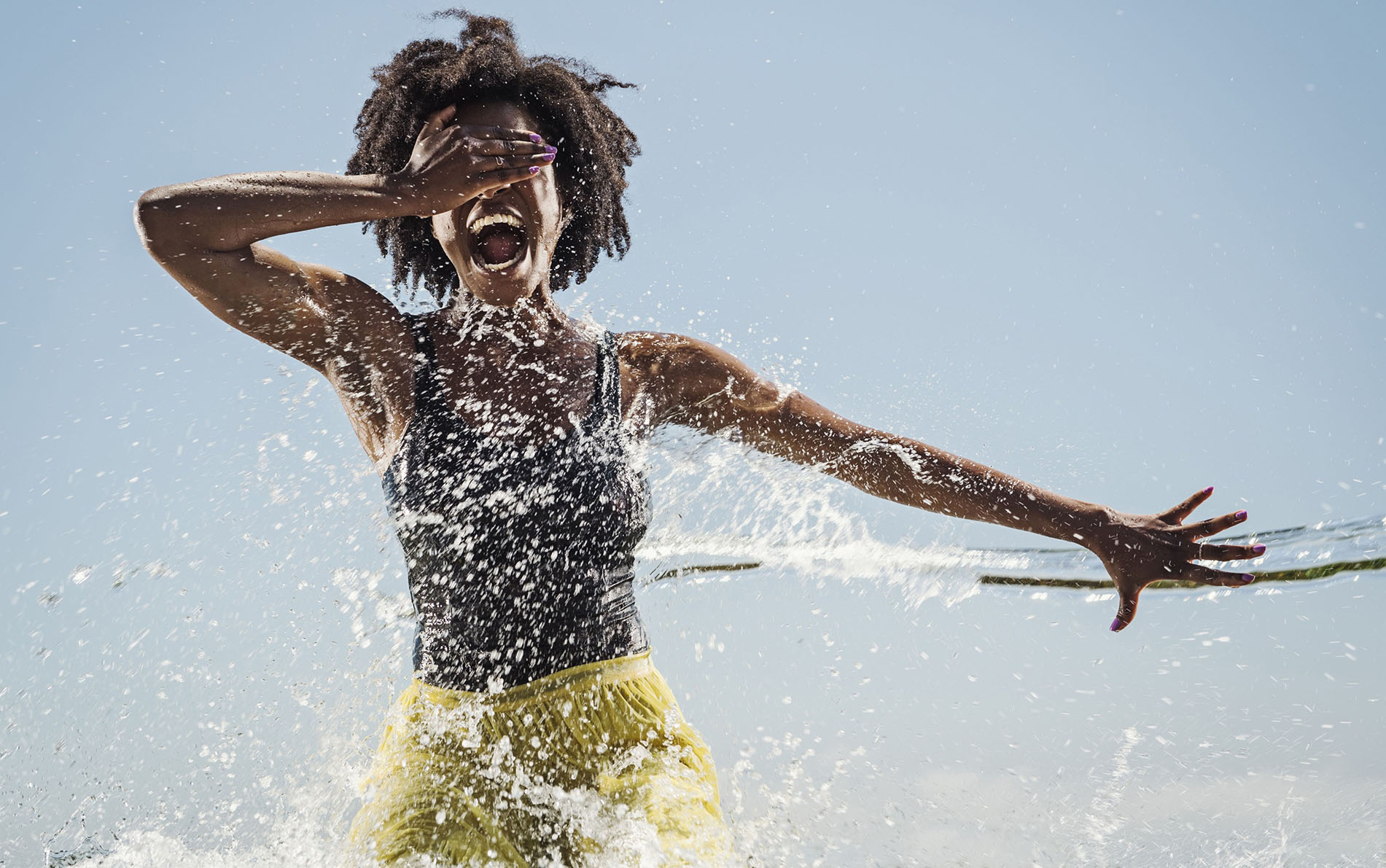 Water spraying on black woman dancing