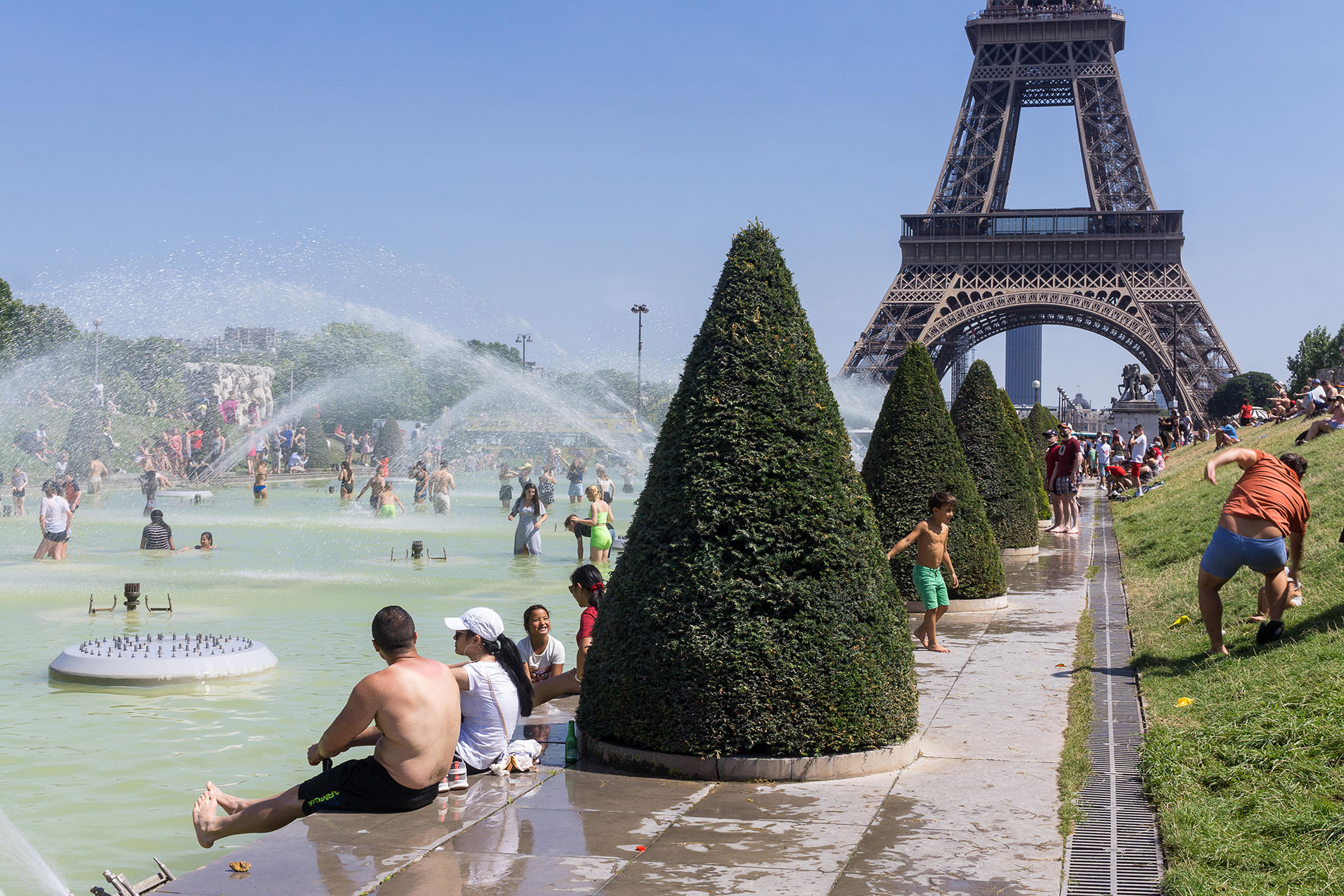 Paris heat wave 2019 - people cooling off and bathing at Jardins de Trocadero fountain in Paris, France, Europe.