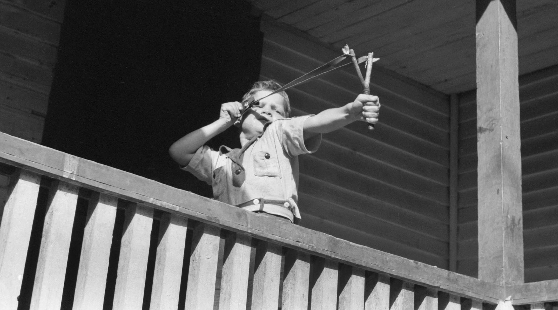 Young Boy Shooting Slingshot from Porch, near Buckhorn, Kentucky, USA, Marion Post Wolcott for Farm Security Administration, September 1940