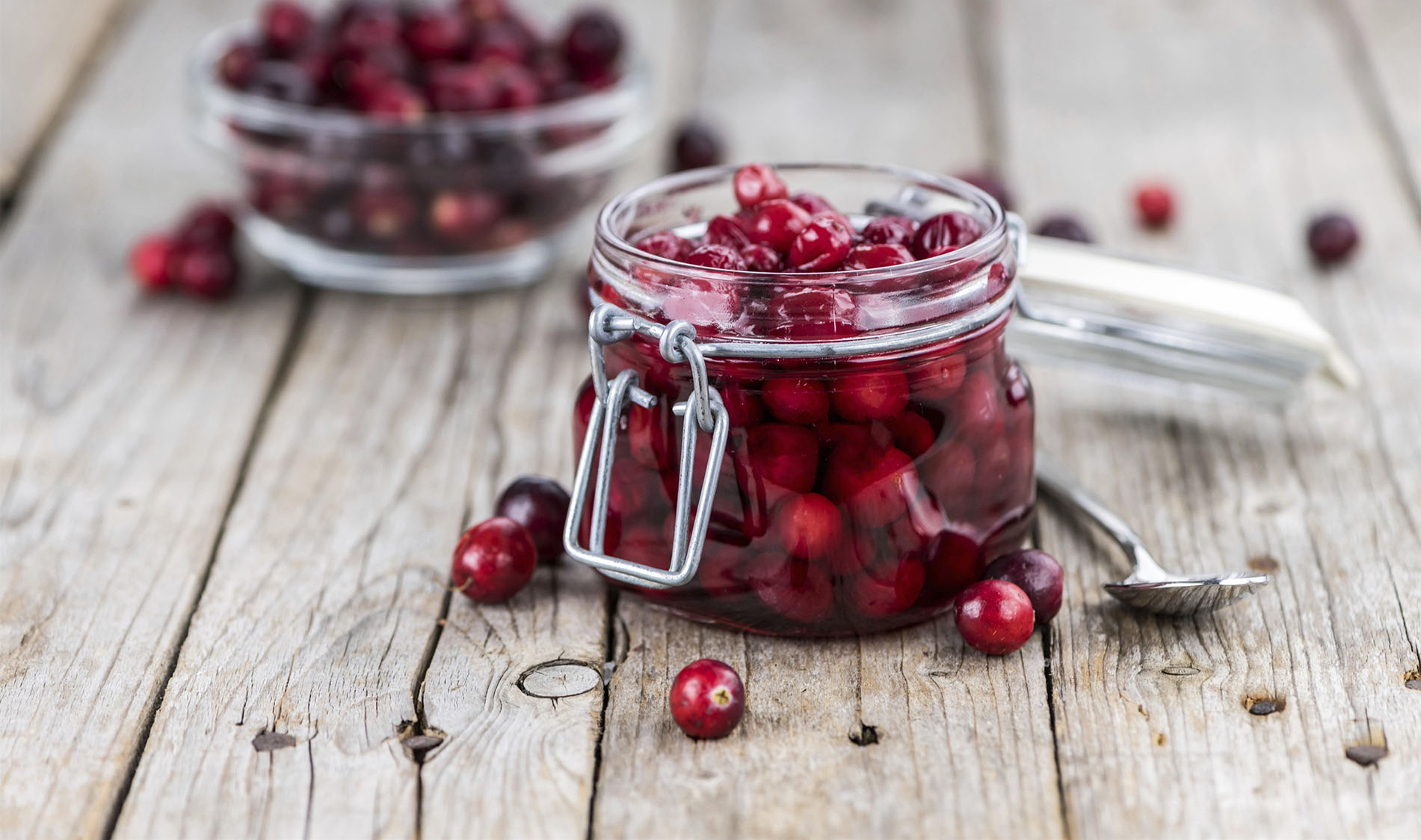 Vintage wooden table with Cranberries (preserved) (selective focus, close-up shot)