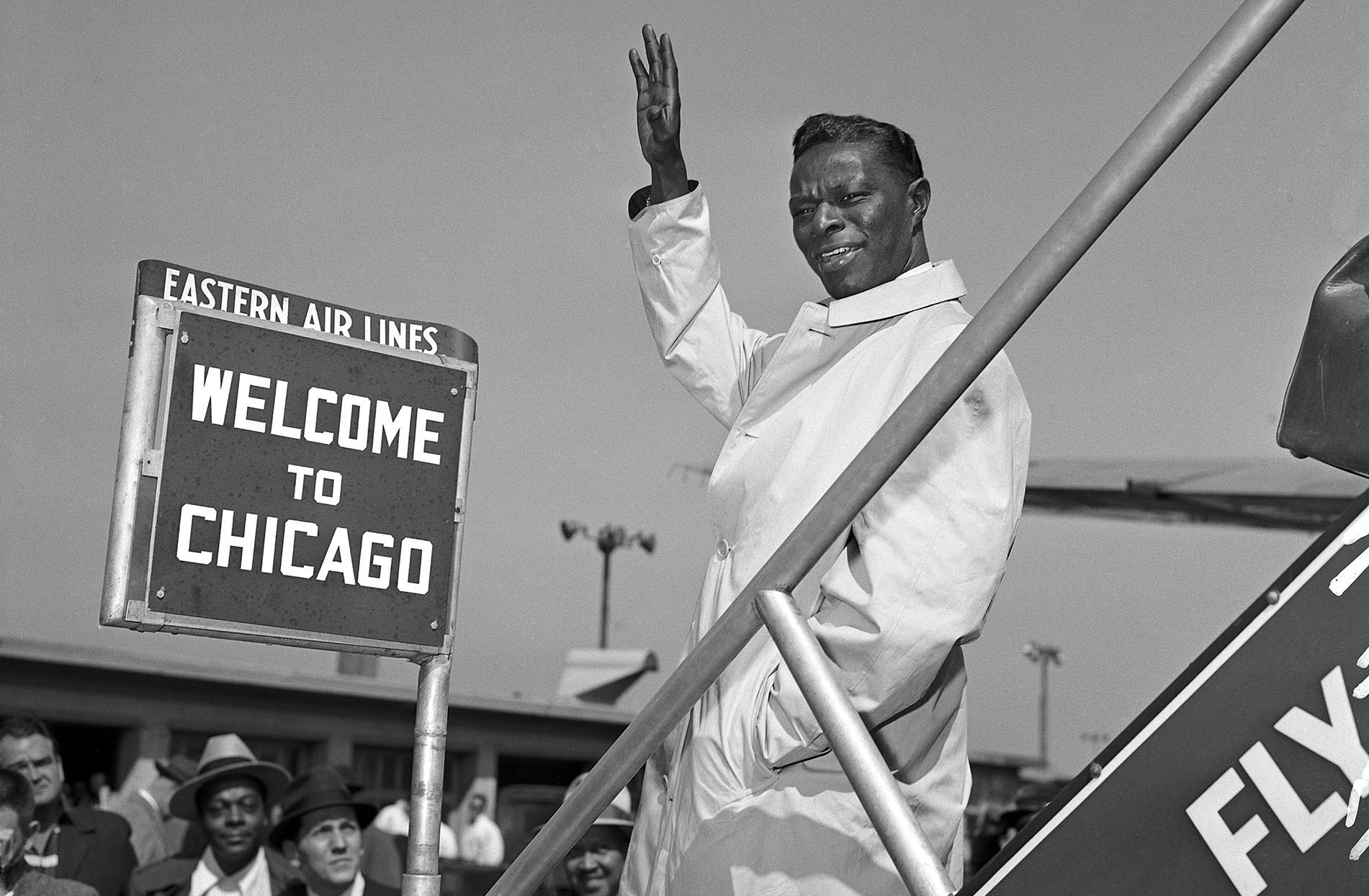 Nat King Cole arriving at Chicago Airport onto the tarmac among a crowd. April 11, 1956.  Original camera negative.