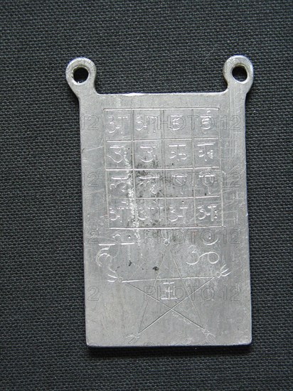 Amulette en plomb gravée de signes ésotériques