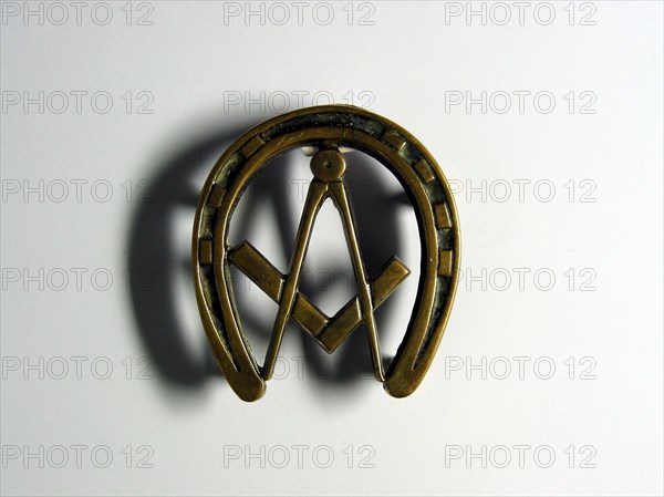Repose plat en bronze en forme de fer à cheval, avec équerre et compas au centre