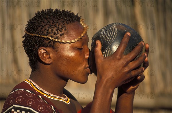 Jeune homme swazi buvant dans un bol d'argile