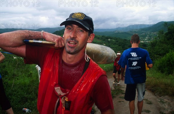 guy carrying front of double, red shirt looking into camera