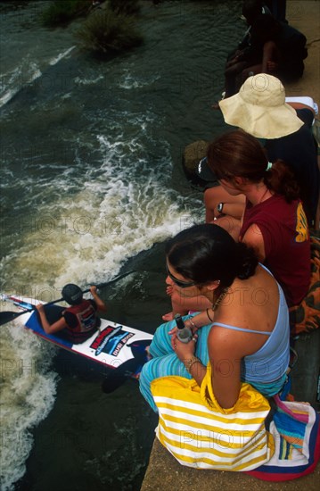 girls on bridge, paddler below