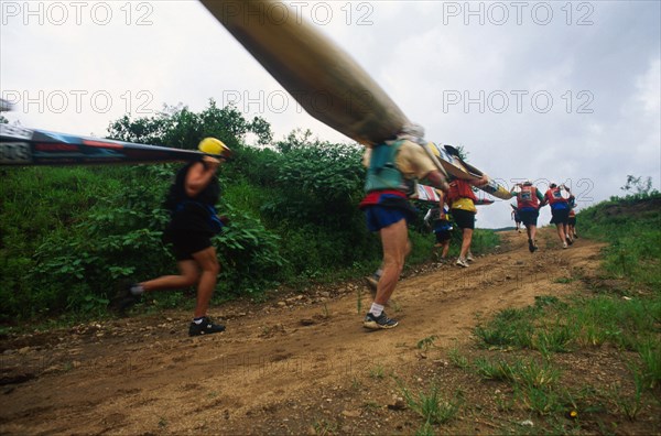 low angle shot, paddlers running by and up short hill