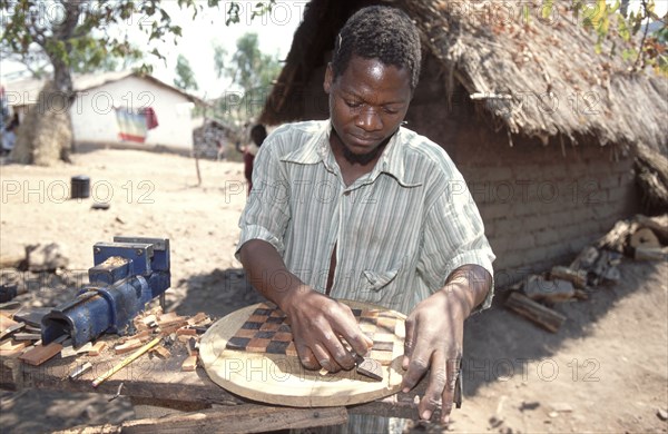 Man making a wooden chess board
\n