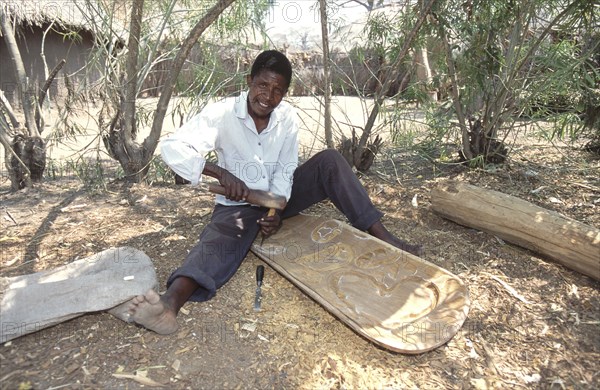 Man carving a woodern chair
\n