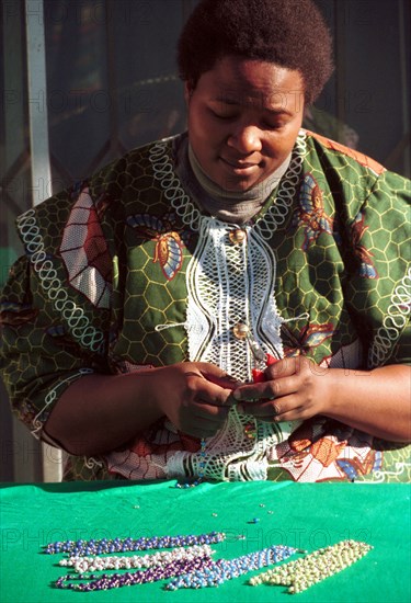 A Xhosa speaking worker creates a necklace from beads at Umtha Beads, a craft business run by David and Cheryl Milligan. The couple started the business after David was laid off work - one of many as companies were restructured in the new South Africa. David now employes many previously unemployed women and exports products to the UK
necklaces, small business, entrepreneurship, beads