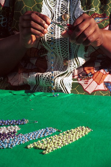Umtha Beads, Cape Town, South Africa 06/1997
A Xhosa speaking worker creates a necklace from beads at Umtha Beads, a craft business run by David and Cheryl Milligan. The couple started the business after David was laid off work - one of many as companies were restructured in the new South Africa. David now employes many previously unemployed women and exports products to the UK
necklaces, small business, entrepreneurship, beads