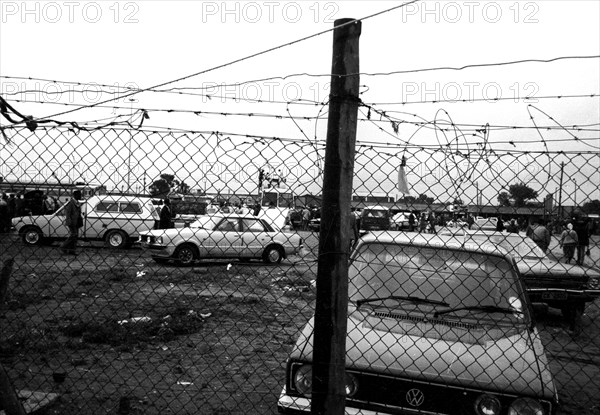 Looking through the fence from Khayamnandi Boys Home, Langa, Cape Town, South Africa, 1989
township, car park, xhosa people, crowded, fence, townships, location, locations, fences, fencing, run down, poverty