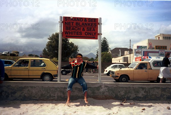 The Strand, Cape Town, South Africa, 1989

whites only sign, signs, signage, politics, political system, systems coloured people, demonstrations against apartheid, beach demonstrations, cars, shops, beach, protest, protests, bias, bigotry, discrimination, illiberality, one-sidedness, partiality, racialism, sectarianism, segregation, unfairness, racism, racist