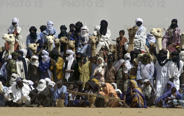 Nomads and animals are seen watching the Wodaabe dance at the Salt Cure festival drawing nomads from all over the region to InGall, near Agadez in Niger on Thursday Sept. 25, 2003.  The Wodaabe men perform a dance, showing off the whiteness of their teeth and eyes, to compete for honour and selection as the most beautiful man by women of the tribe at the festival celebrated at the end of the rainy season. (Photo/Christine Nesbitt)