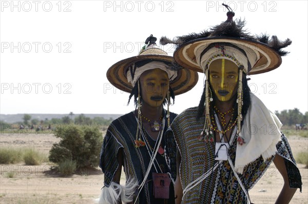 Wodaabe men prepare to perform a dance of male beauty at a festival in InGall, near Agadez in Niger on Friday Sept. 26, 2003. The Wodaabe, a nomadic West African tribe, value male beauty and are taught from an early age to look into mirrors to consider their appearance. The Wodabe men perform a dance, showing off the whiteness of their teeth and eyes, to compete for honour and selection as the most beautiful man by women of the tribe at a festival celebrated at the end of the rainy season. (Photo/Christine Nesbitt)