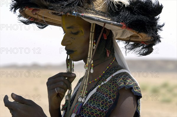 Wodaabe men examine their appearance in handmirrors at a festival in InGall, near Agadez in Niger on Friday Sept. 26, 2003. The Wodaabe, a nomadic West African tribe, value male beauty and are taught from an early age to look into mirrors to consider their appearance. The Wodaabe men perform a dance, showing off the whiteness of their teeth and eyes, to compete for honour and selection as the most beautiful man by women of the tribe at a festival celebrated at the end of the rainy season.  (Photo/Christine Nesbitt)
