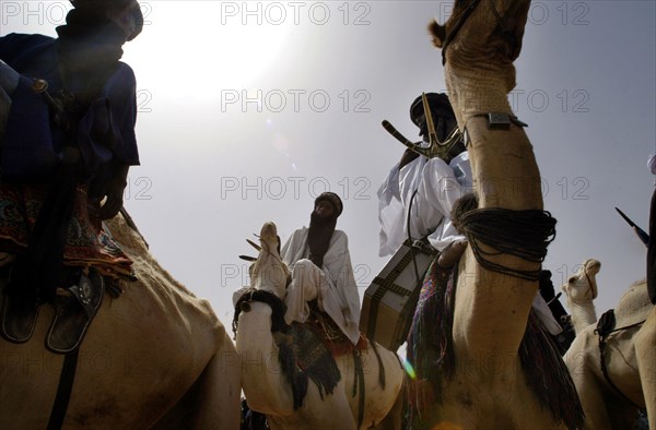 Nomads are seen on camels at the Salt Cure festival drawing nomads from all over the region to InGall, near Agadez in Niger on Thursday Sept. 25, 2003.  The Wodaabe men perform a dance, showing off the whiteness of their teeth and eyes, to compete for honour and selection as the most beautiful man by women of the tribe at the festival celebrated at the end of the rainy season. (Photo/Christine Nesbitt)