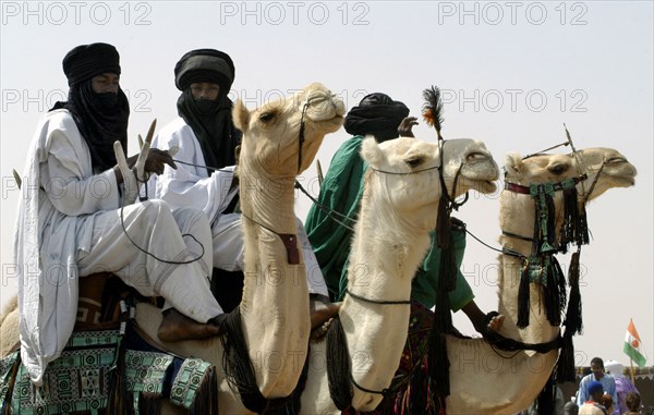 Nomads are seen on camels at the Salt Cure festival drawing nomads from all over the region to InGall, near Agadez in Niger on Thursday Sept. 25, 2003.  The Wodaabe men perform a dance, showing off the whiteness of their teeth and eyes, to compete for honour and selection as the most beautiful man by women of the tribe at the festival celebrated at the end of the rainy season. (Photo/Christine Nesbitt)