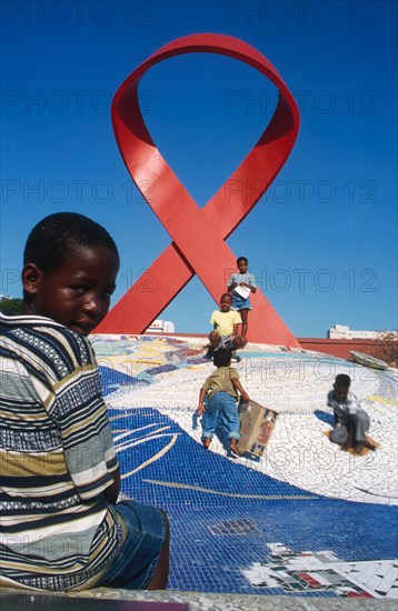 children in front of the AIDS ribbon