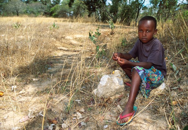 Child sitting beside path