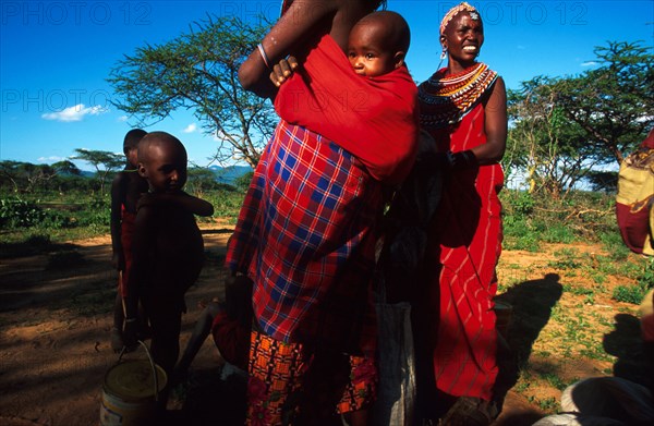 Women at Nagorowuro get ready to walk home after collecting their ration of grain