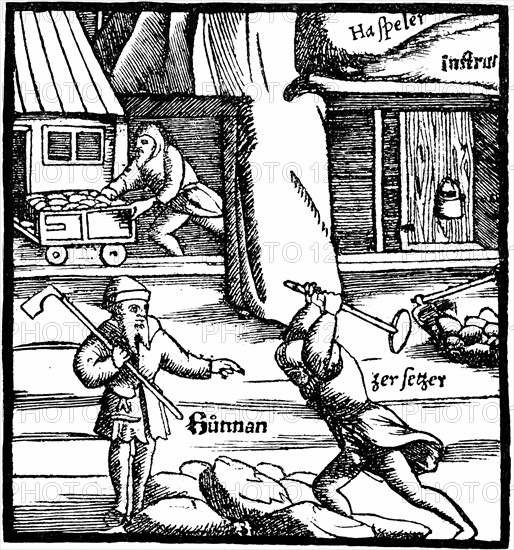 Au premier plan, on casse le minerai avec un marteau, en  arrière plan, un homme sort de la mine en conduisant un chariot rempli de minerai