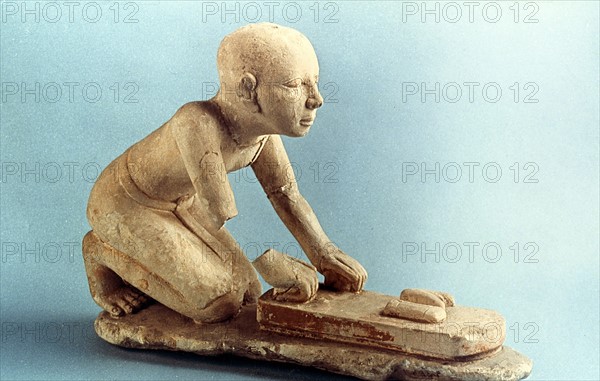 Model of a baker kneading dough and forming loaves