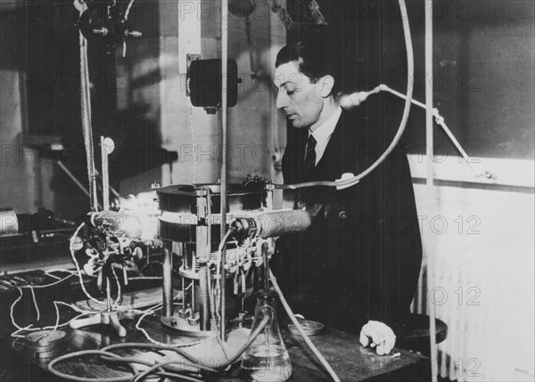(Jean) Frederick JOLIOT-CURIE (1900-1958), French physicist, in about 1930. The apparatus is a Wilson cloud chamber. Joliot became assistant to Marie Curie in 1925. In 1926 married Irene Curie and in 1935 shared with her the Nobel prize for chemistry for