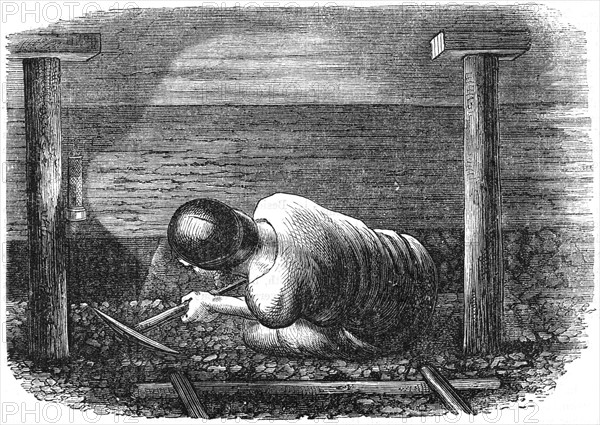 Miner working a seam with a pick 'scuffling' out the coal