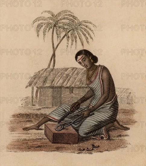 Femme d'un dinandier indien corrigeant les imperfections d'un petit objet en laiton