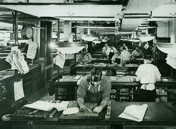 Compositors set metal type faces in a newspaper composition room