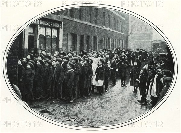 School children in the East End of London queueing for free meals, c1910