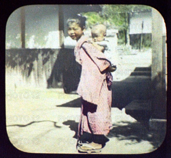 Young Japanese mother carrying her baby on her back