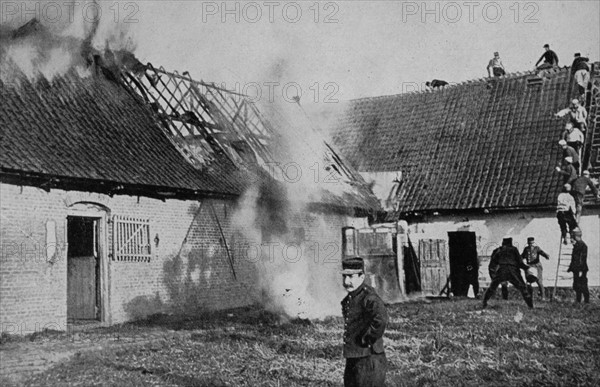 Maisons en feu après un tir d'obus allemand