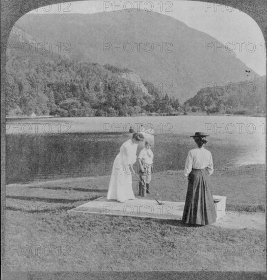 Woman and boy with golf clubs in foreground