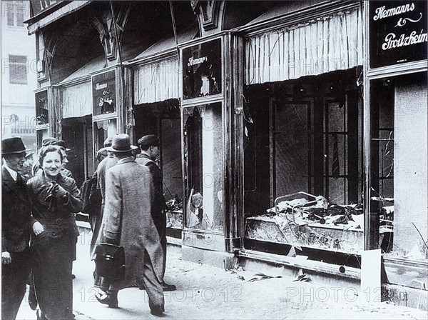 Pedestrians glance at the broken windows