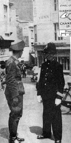 German army officer talking to a policeman in British  uniform
