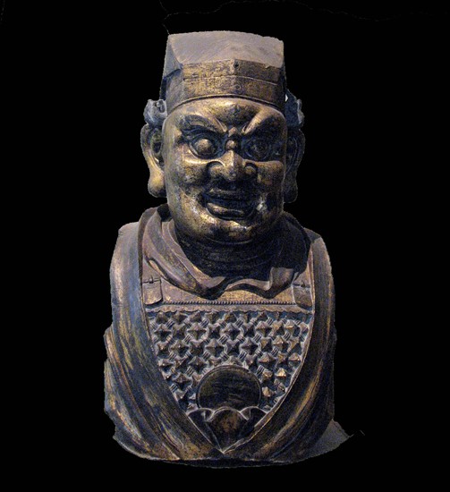 Gilt bronze head of a Buddhist guardian figure.  Yuan dynasty /  14th century AD.  Fierce armoured guardian figures were placed at the entrances to Buddhist temples in a protective capacity.