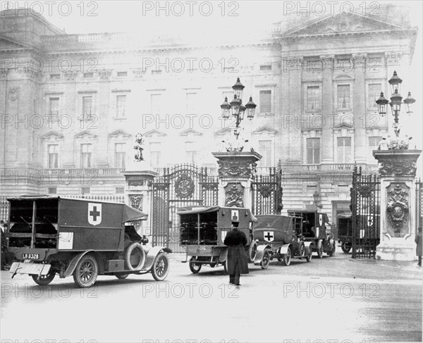 Convoy of motorised ambulances organised by the British Red Cross arriving at Buckingham Palace, London, to be reviewed by the King George V. Photograph.