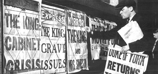 Newspaper seller adjusting his headline posters