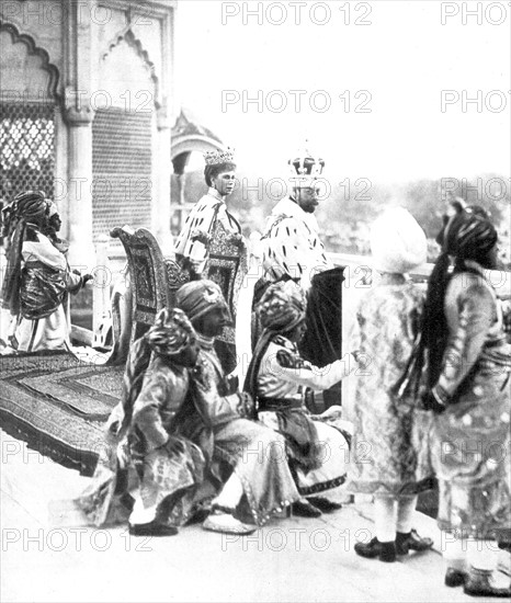 George V, King of Great Britain 1910-1936, with his consort Queen Mary, watching Delhi Durbar from the Red Fort, accompanied by the Indian princes acting as pages.  India, 1911.