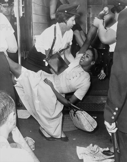 African American woman being carried to police patrol wagon during demonstration in Brooklyn