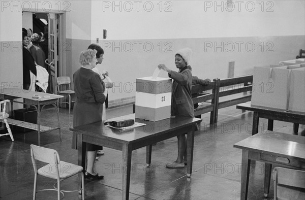 Young African American woman casting her vote in a ballot box