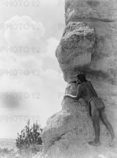 San Ildefonso man peering from behind large rock formation