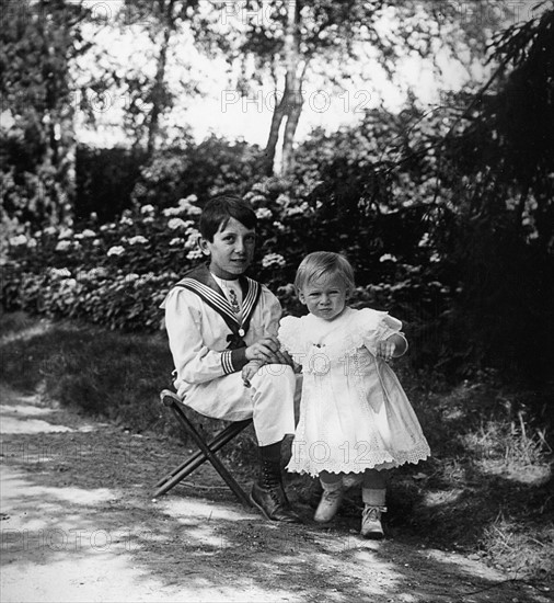 Young French children play in a garden