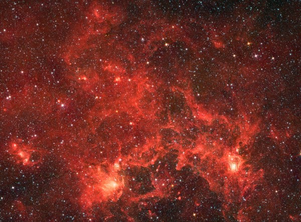 The nebula nicknamed 'the Dragonfish.' This turbulent region, jam-packed with stars, is home to some of the most luminous massive stars in our Milky Way galaxy. It is located approximately 30,000 light-years away in the Crux constellation. Spitzer.