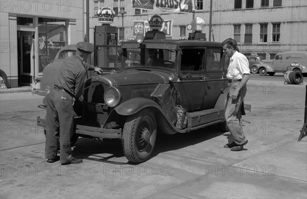 Auto of migrant fruit worker at gas station, 1940