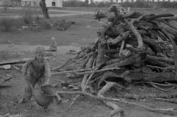 Child of white migrant worker playing with automobile tools near Harlingen