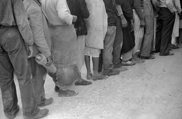 Vegetable workers, migrants, waiting after work to be paid. Near Homestead, Florida dated 19380101